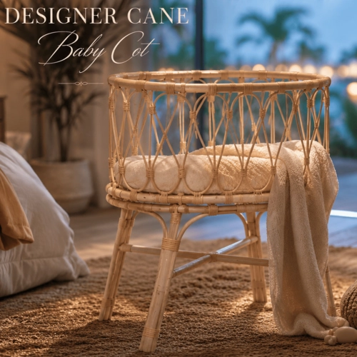 Elegant handcrafted cane baby cot made from natural rattan, photographed in a dramatic studio setting with soft atmospheric lighting and a blurred cyan and amber bokeh background. The minimalist baby cot features intricate woven cane detailing, warm natural textures, and a luxurious high-end tropical aesthetic.
