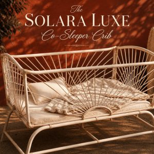 Luxury Solara Luxe Co-Sleeper Crib handcrafted from woven cane with a sunburst design, styled with soft bedding and neutral nursery décor in a warm boho-inspired setting.