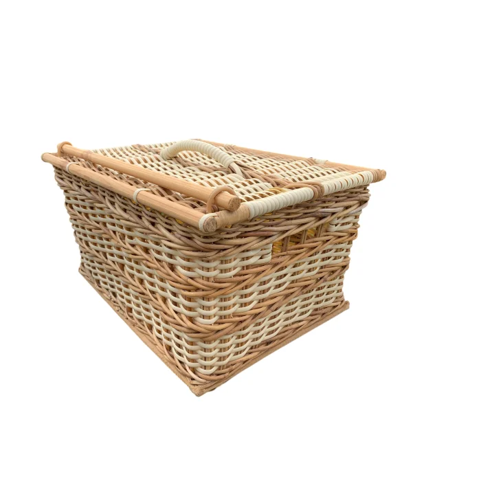 Traditional handcrafted cane picnic basket shown from a three-quarter side angle with natural and white Palembang cane weave, reinforced frame and woven carry handle.